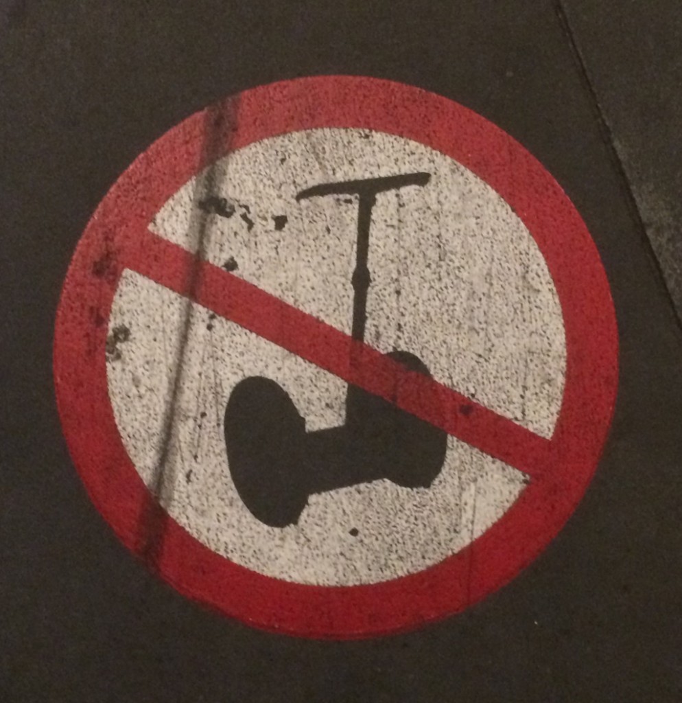 Sign on sidewalk disallowing segway scooters